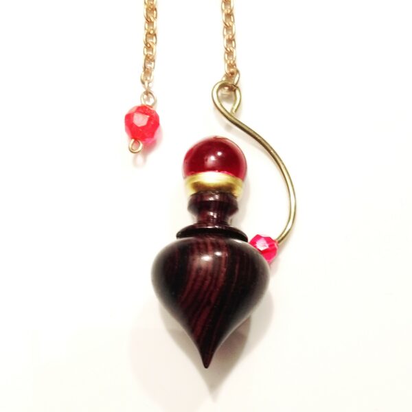 PENDULE ISIS EN BOIS PRECIEUX, LAITON ET SPHERE DE CRISTAL ROUGE